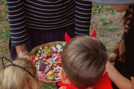 Children take candy from a basket. Halloween. Selective focus.の写真素材
