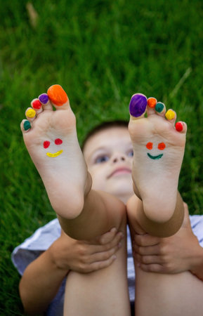 a smile painted with paints on the child's arms and legs. selective focusの写真素材