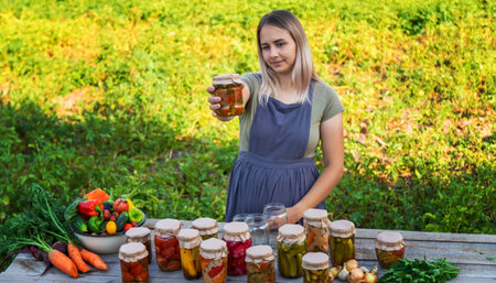A woman preserves vegetables in jars. selective focus. food.の写真素材