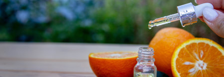 bottle of aromatic essence and fresh orange on the background of natureの写真素材