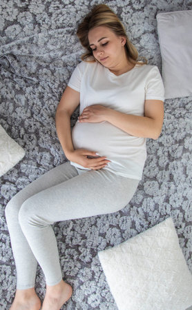 Pregnant woman has stomach ache. Selective focus. Home.