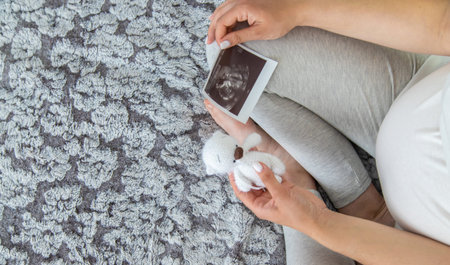 A pregnant woman collects baby things. Selective focus. Home.