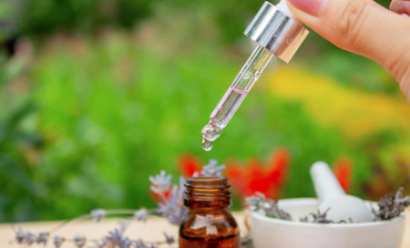 Glass bottle of lavender essential oil on a wooden backgroundの写真素材