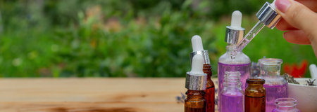 Glass bottle of lavender essential oil on a wooden backgroundの写真素材