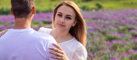 Beautiful happy couple in lavender field having fun on flower meadow, summer nature, love conceptの写真素材