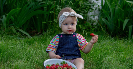 little girl eating strawberries in the garden. Selective focus.