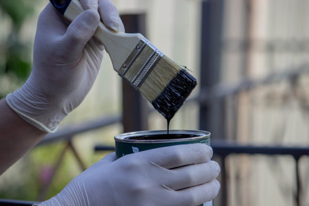 close-up of a hand painting a metal pipe. Selective focus.の写真素材