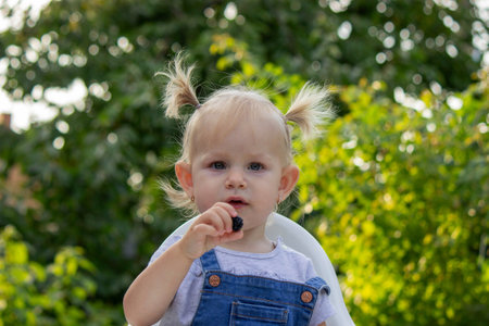 little happy girl eating blackberry. Selective focus.の写真素材