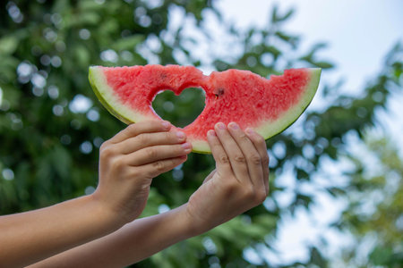 boy eats watermelon on the background of nature. Selective focus.の写真素材
