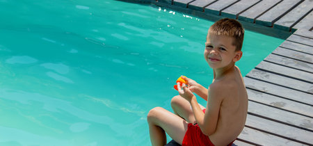 A child applies sunscreen on the background of a swimming pool. protection from the sun