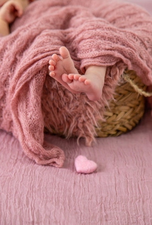 newborn baby sleeping on a pink backgroundの写真素材