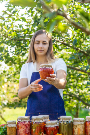 woman canning tomatoes cucumbers vegetables on the background of nature. Selective focus.