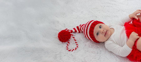 Christmas portrait of a cute little newborn baby girl wearing a Santa Claus hat or knitted cap. Christmas time.の写真素材