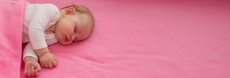 Baby sleeping on a pink background with a pink teddy bear.child.の写真素材