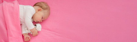 Baby sleeping on a pink background with a pink teddy bear.child.の写真素材