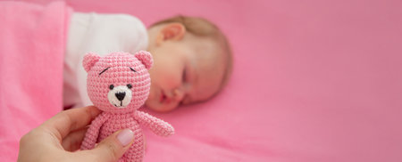 Baby sleeping on a pink background with a pink teddy bear.child.の写真素材