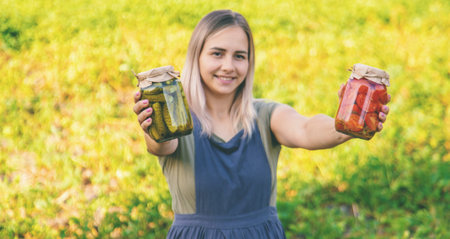 A woman preserves vegetables in jars. Selective focus.