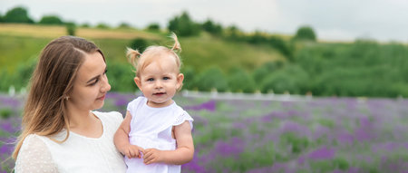 Happy mother and daughter in a lavender field.の写真素材