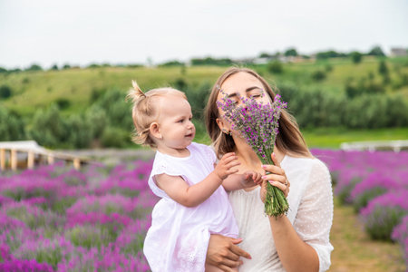 Happy mother and daughter in a lavender field.の写真素材