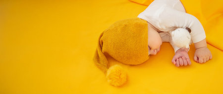 Baby sleeps on a yellow background. Selective focus.の写真素材