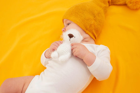 smiling baby girl lying on a yellow background. babyの写真素材