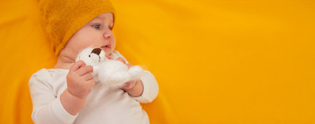 smiling baby girl lying on a yellow background. babyの写真素材