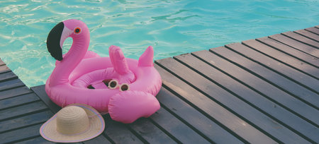 inflatable flamingo circle on the background of the pool and a straw hat.restの写真素材