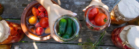 woman canning tomatoes cucumbers vegetables on the background of nature. Selective focus.