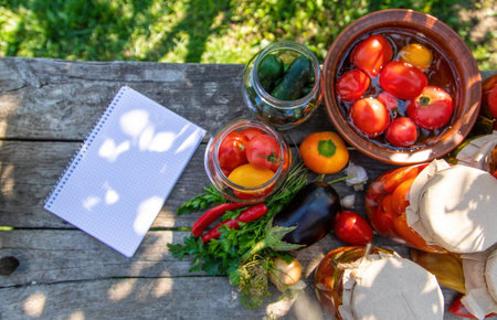 woman canning tomatoes cucumbers vegetables on the background of nature. Selective focus.の写真素材