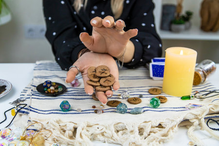 The fortune teller reads with runes in her hands. Selective focus. woman.の写真素材