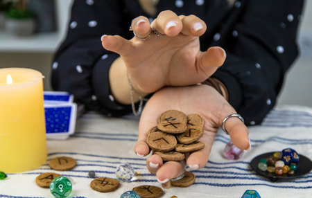 The fortune teller reads with runes in her hands. Selective focus. woman.の写真素材