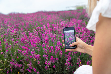 Woman in lavender field. Happy carefree woman in white dress and hat walking through lavender field.