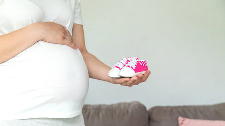 Pregnant woman baby boots belly. Selective focus. cute.