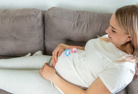 Pregnant woman baby pacifiers pink and blue. Selective focus. cute.