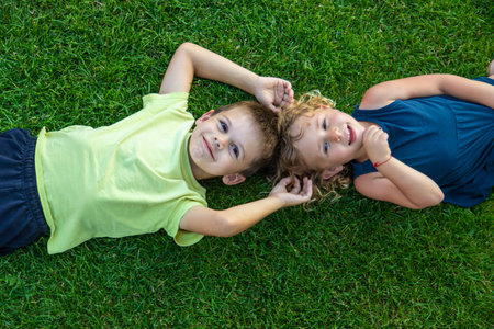 Child lying on green grass. Child looking at camera.の写真素材