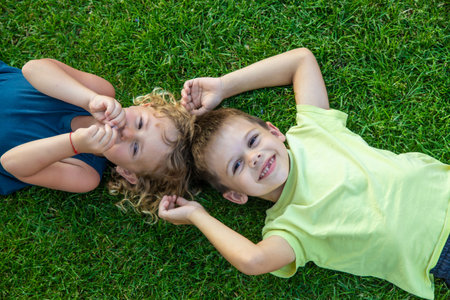 Child lying on green grass. Child looking at camera.の写真素材