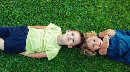Child lying on green grass. Child looking at camera.の写真素材
