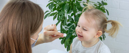 Female doctor giving little girl vitamin or ascorbic. Pediatrician's appointment, healthcare concept