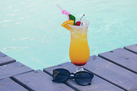 A nice cocktail, hat and sunglasses by the pool.の写真素材