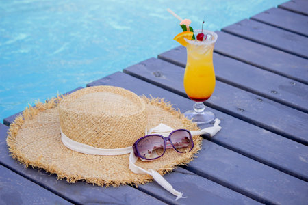 A nice cocktail, hat and sunglasses by the pool.の写真素材