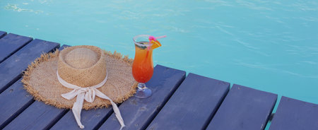 A nice cocktail, hat and sunglasses by the pool.
