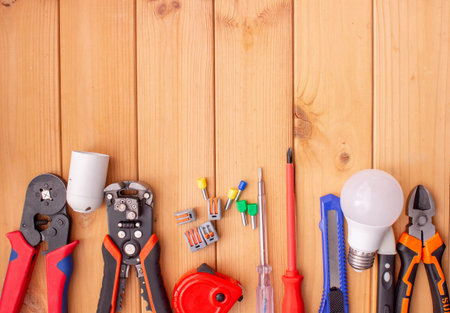 Electrical Tools and Components on Wooden Background.