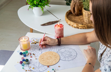 Woman astrologer draws a natal chart. Selective focus.の写真素材
