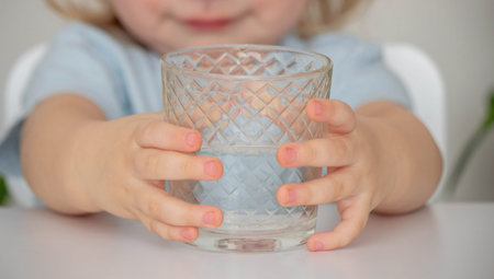 little girl drinks water from a glass. Selective focus.