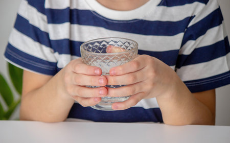 Boy drinking water from a glass. Selective focus.の写真素材