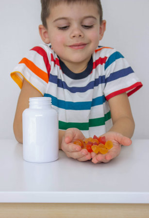 The boy eats jelly beans or takes vitamins.