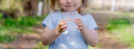 little girl drinking water from a glass.の写真素材