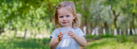 little girl drinking water from a glass.の写真素材