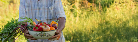 Man holding a bowl of vegetables in the garden. Selective focus.の写真素材