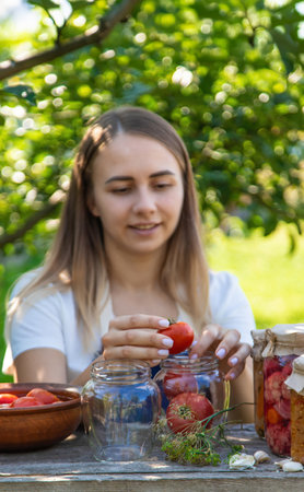 Woman Preserving Tomatoes and Vegetables in Garden.の写真素材